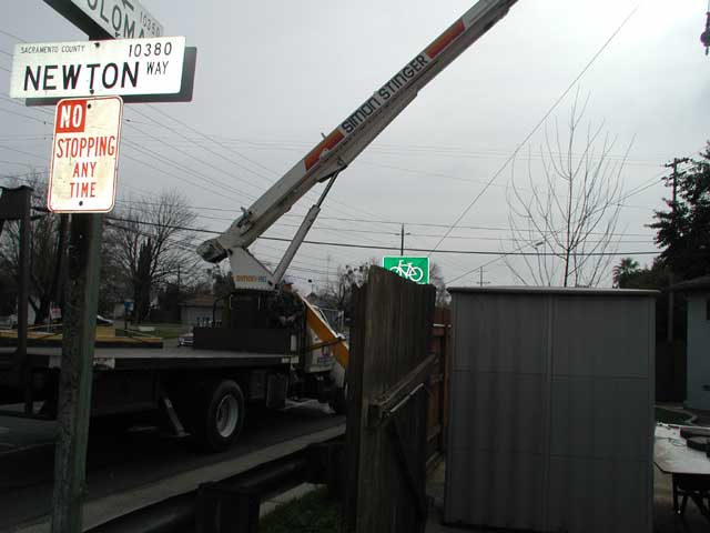 Crane reaching over fence