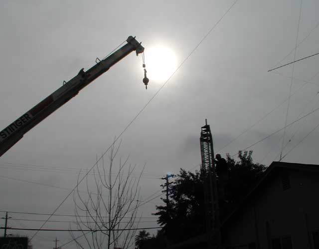 Crane backing away from erect tower